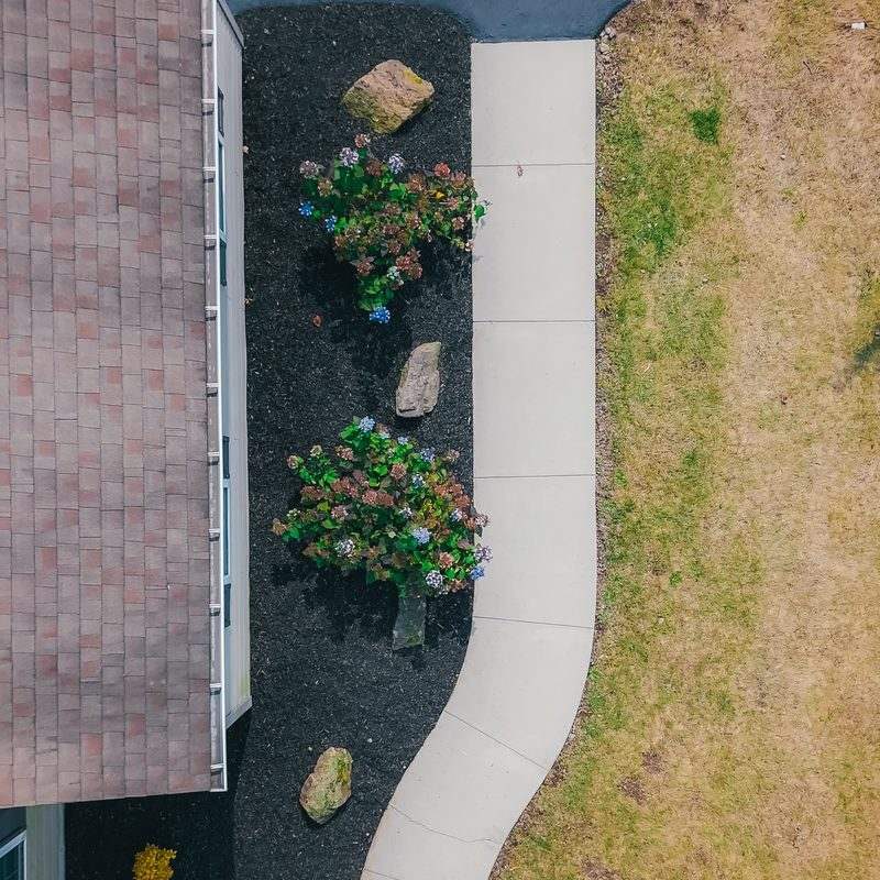 Aerial view of a walkway lined with mulch beds and flowers