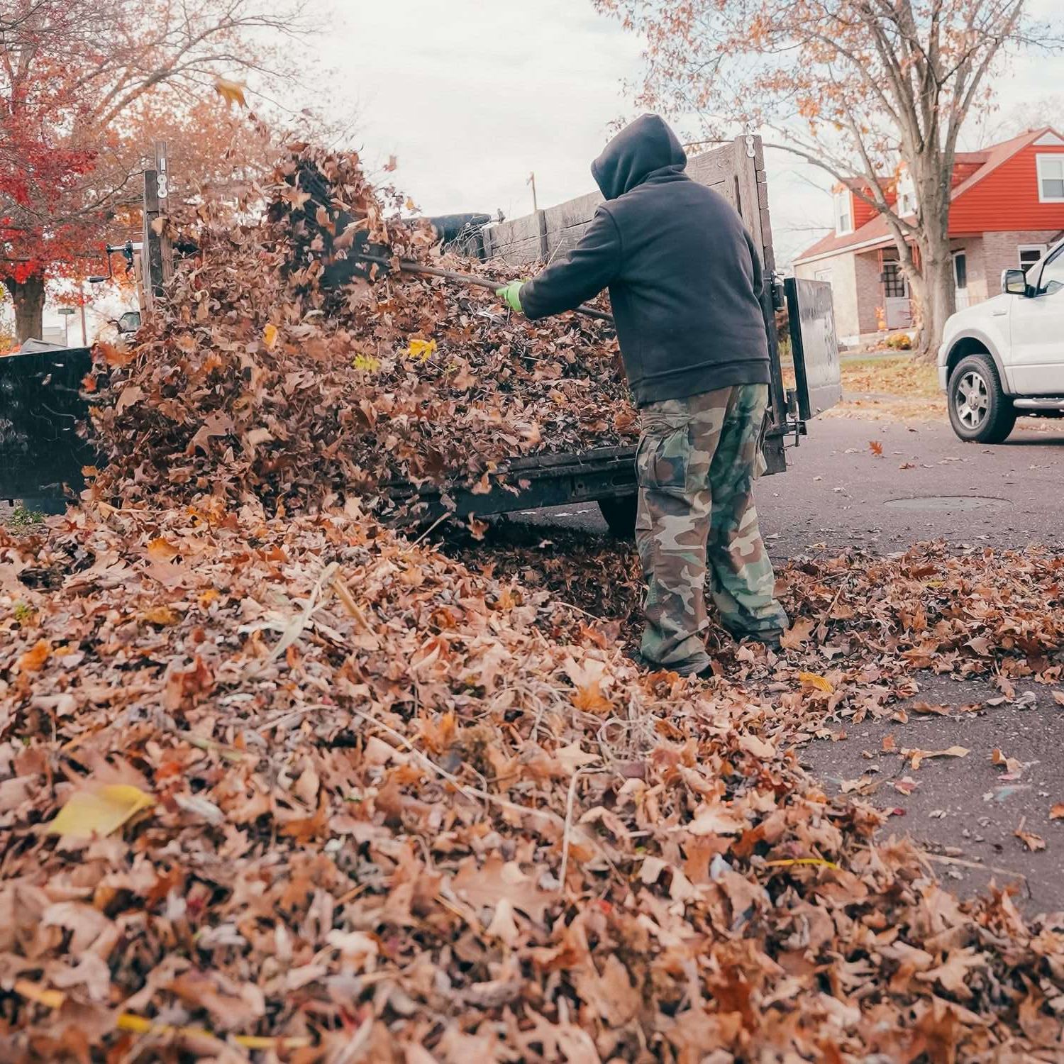 Anderson Lawn Care crew clearing a large pile of fall leaves