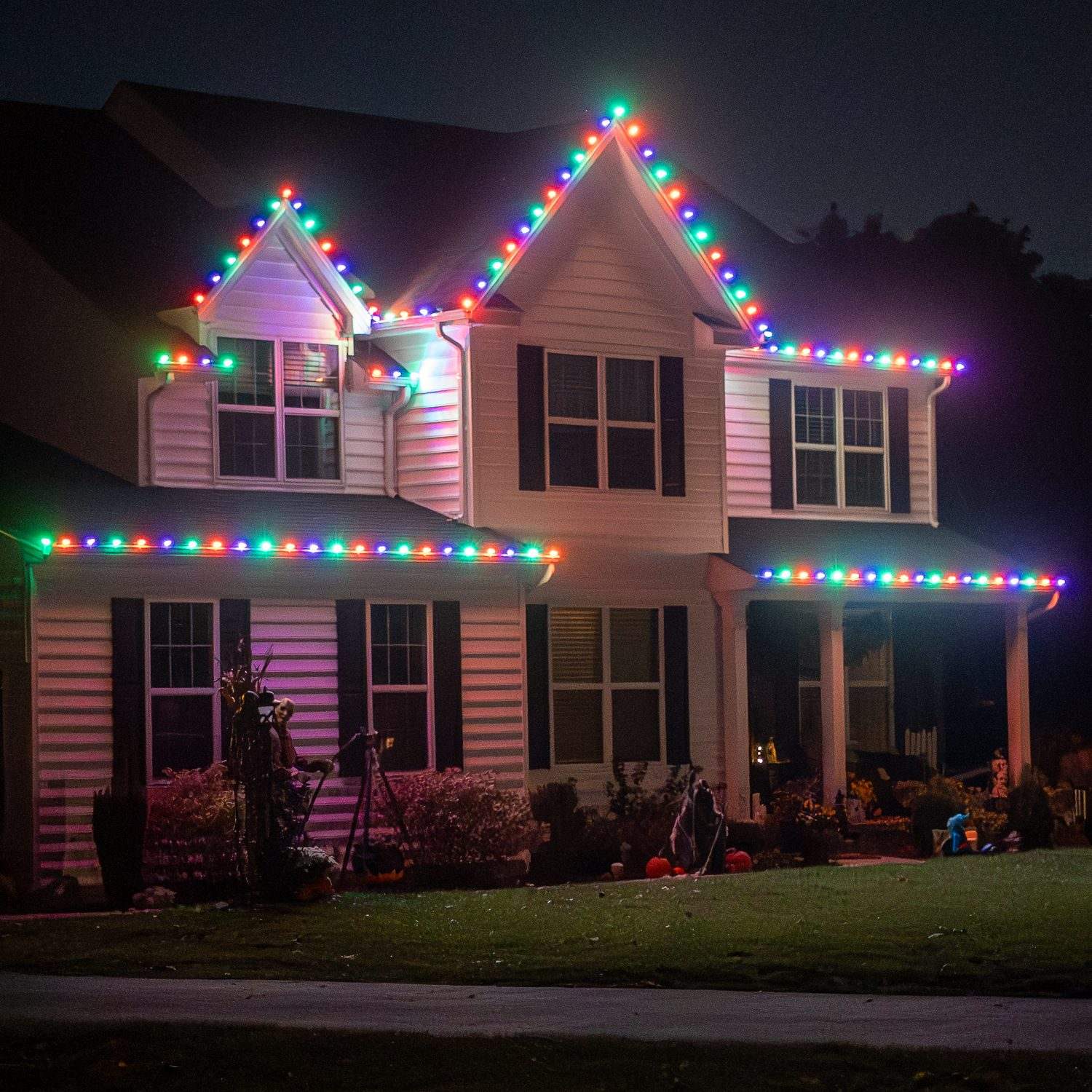 House with professionally installed holiday roofline lights at night