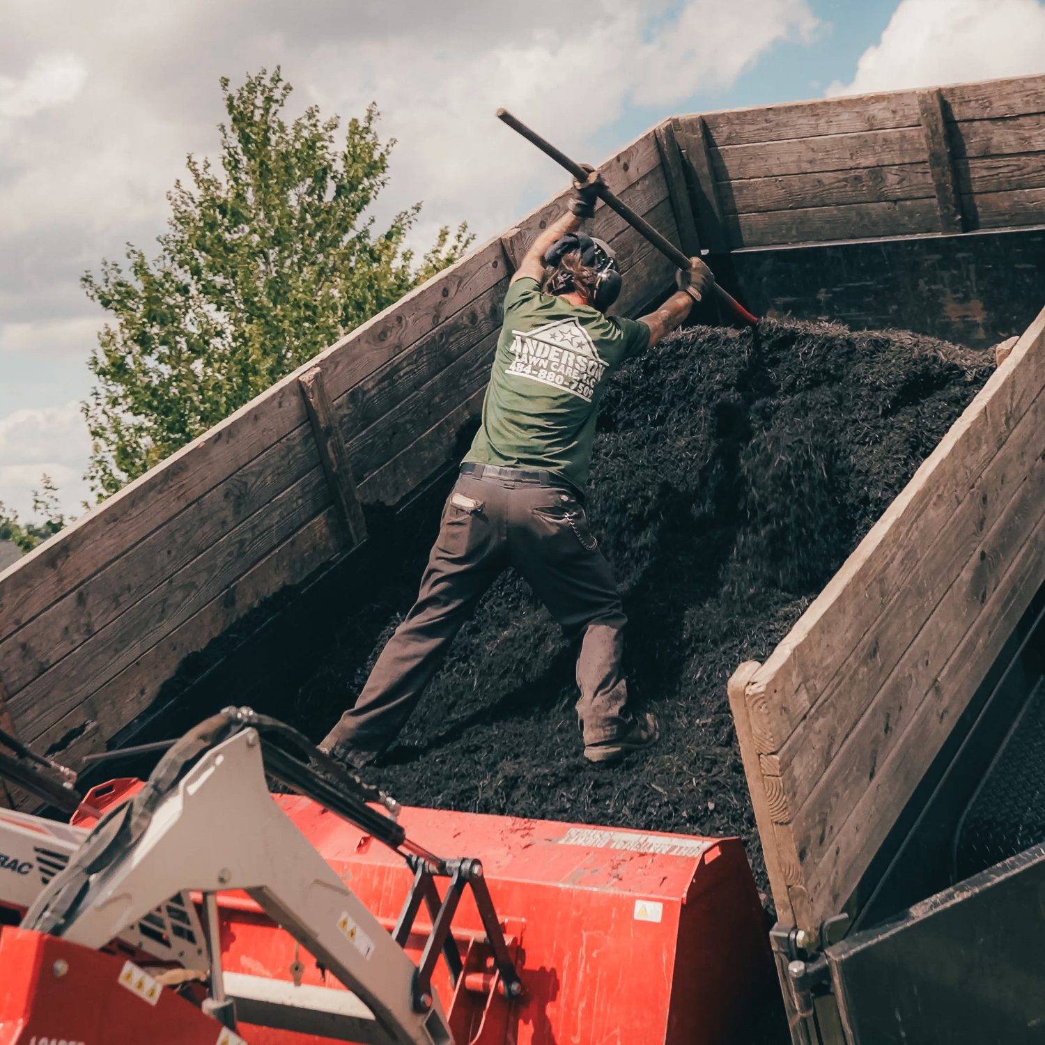 Crew member loading fresh mulch from the truck
